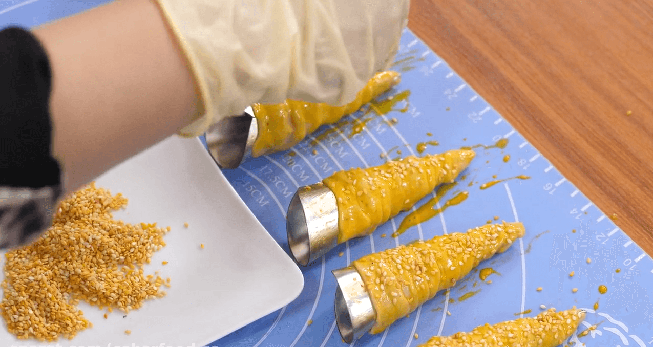 پاشیدن گنجد روی خمیر